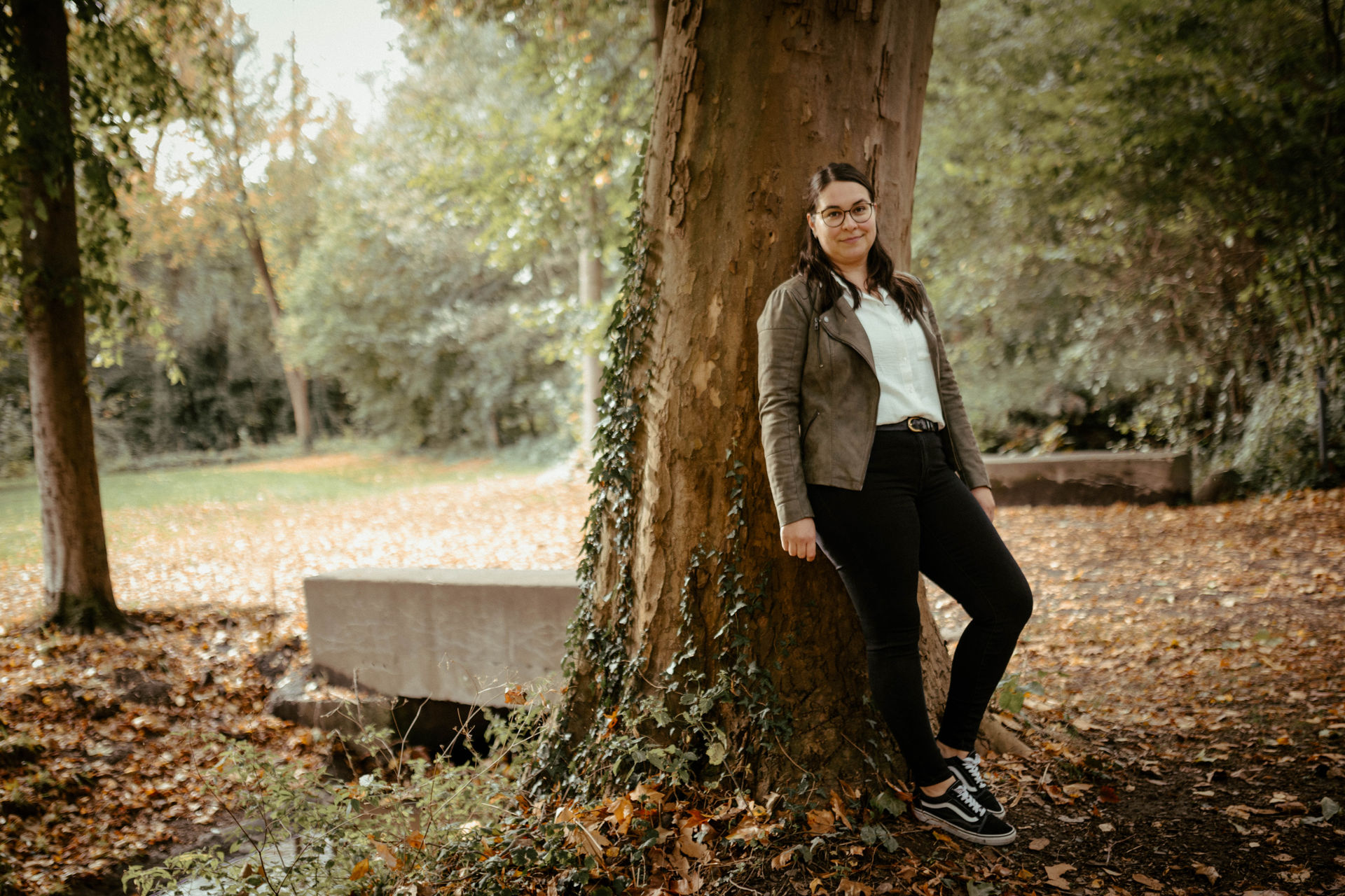 Webdesignerin Judith Geisen lehnt an einem Baum im Park